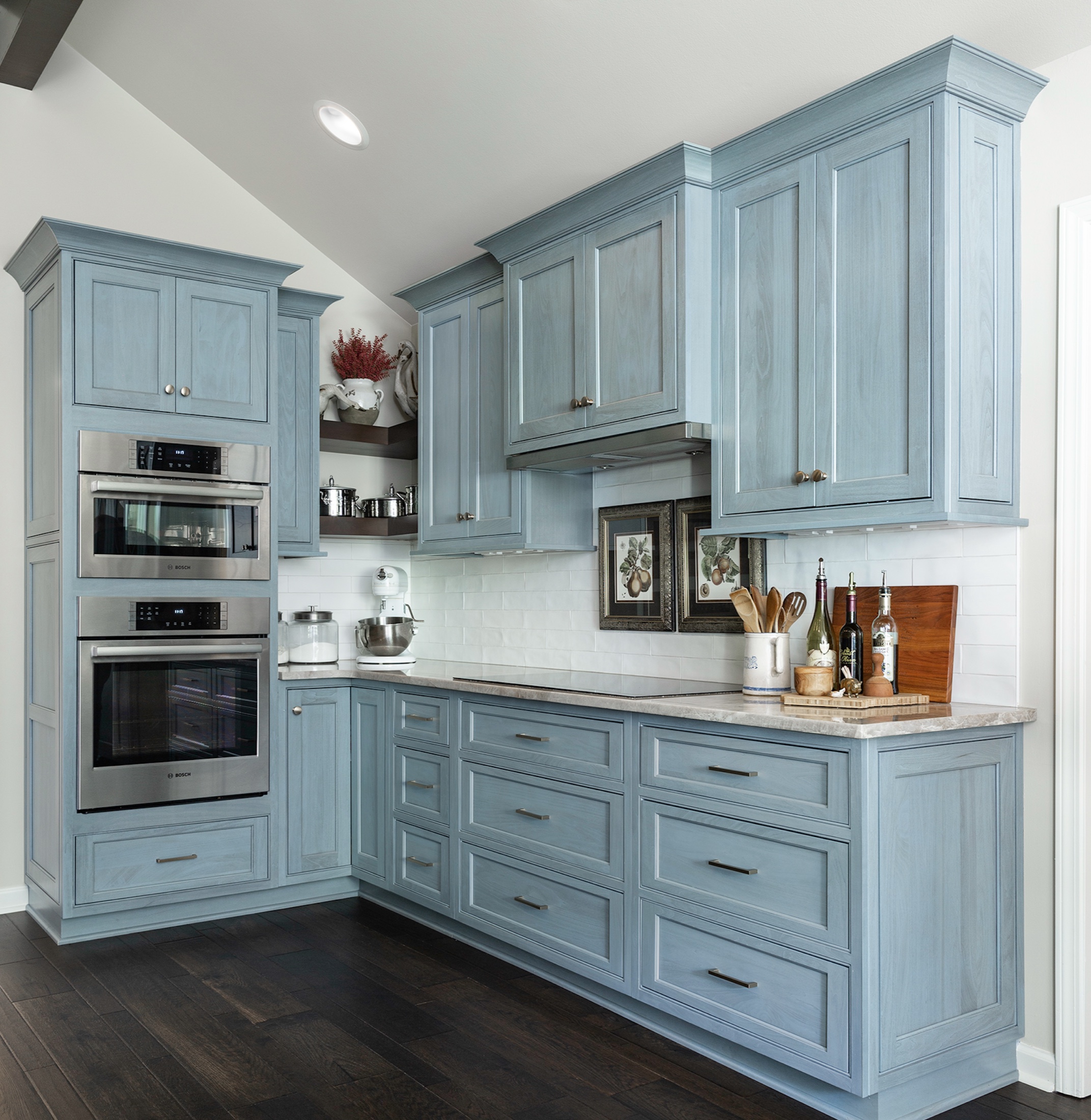 Blue custom cabinetry with integrated double ovens and detailed crown molding